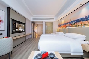 A hotel room with a bed, bedside table, a desk with a chair, a large window, and a wall-mounted TV. - Vienna International Hotel (Wuhan Yellow Crane Tower Pengliuyang Subway Station) (Wuhan)