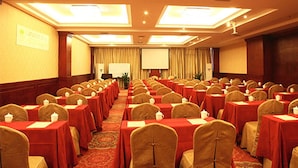 A conference room with rows of tables and chairs, a projector screen, and a podium. - Vienna International Hotel (Wuhan Yellow Crane Tower Pengliuyang Subway Station) (Wuhan)