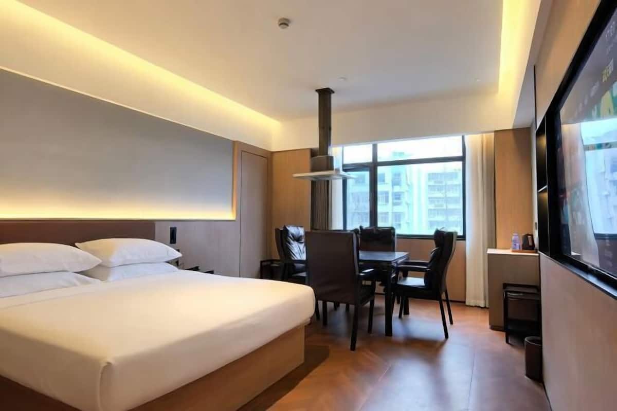 Une chambre d’hôtel avec un lit, un bureau et une chaise.