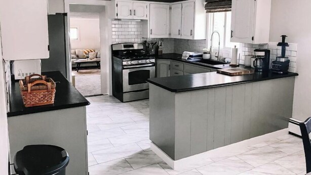 A modern kitchen with grey cabinets, a central island, and a stove. - Kennerdell Country Retreat with seasonal inground pool (Kennerdell)