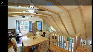 Ein Holzinnenraum mit Essbereich, Deckenventilatoren und einer Treppe.