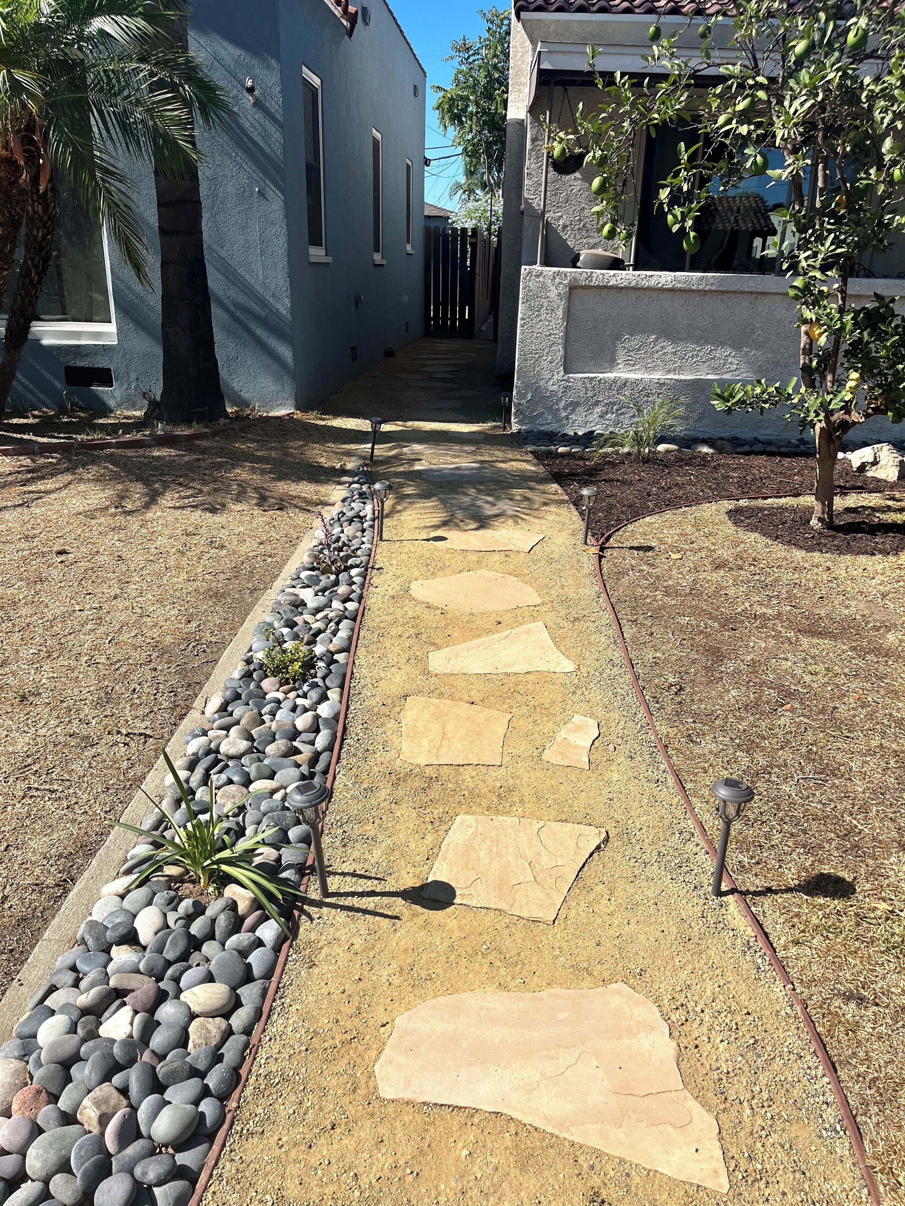 A pathway with stepping stones leading to a building entrance.