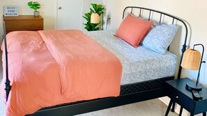 A bedroom with a bed, a ceiling fan, a bedside table with a lamp, and a door. - Spacious private studio in Long Beach (Long Beach)