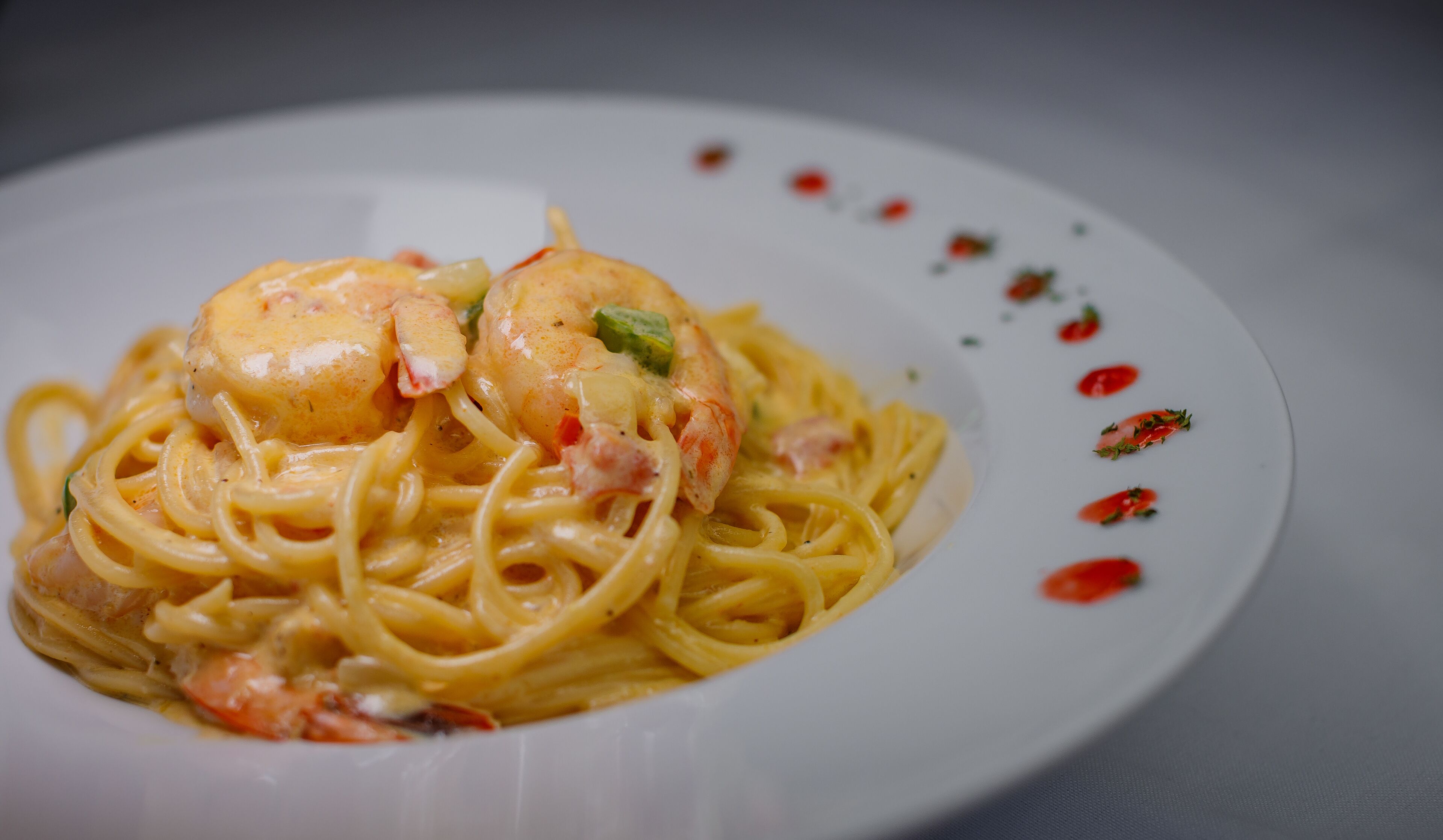 A plate of spaghetti with shrimp and a creamy sauce.