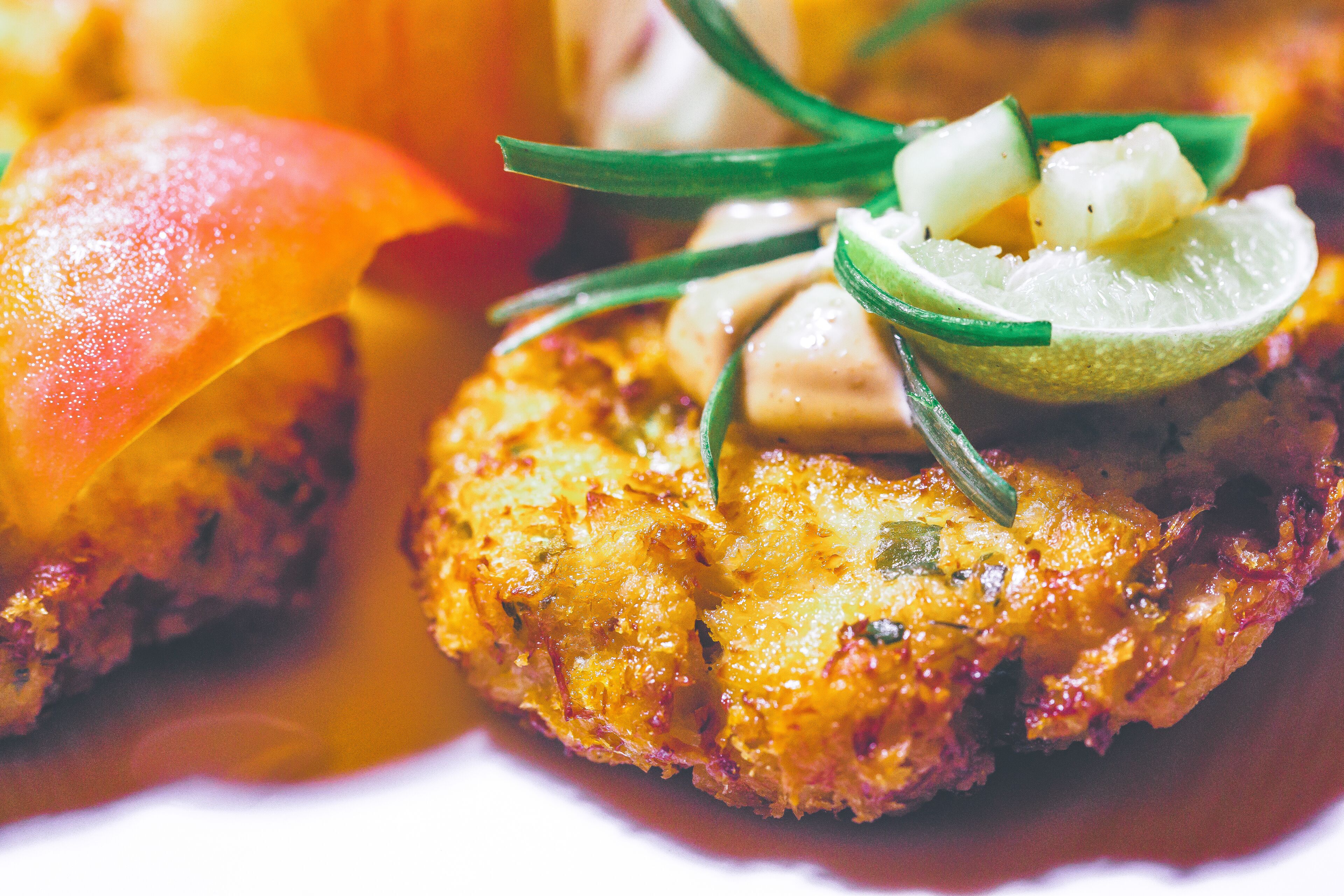 Une vue rapprochée d’un plat dont la croûte est dorée, garni d’herbes vertes et d’une tranche de citron vert.