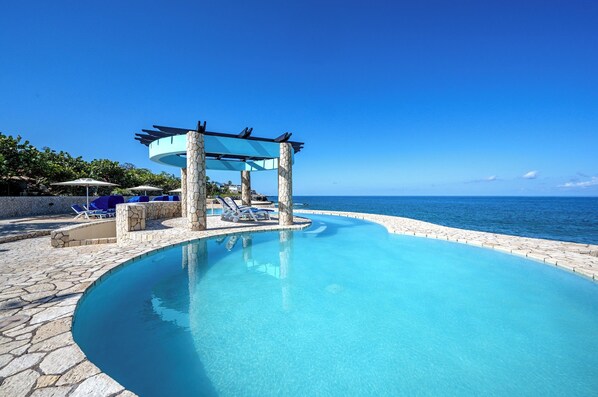 Alberca al aire libre y camastros