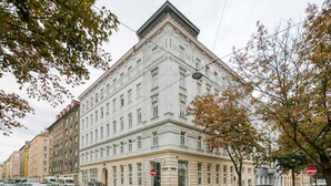 A large, historic building with a symmetrical facade, multiple windows, and a prominent entrance.