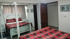 A bedroom with a bed, a wardrobe, a desk, and a chair. - Recidencial Brisas del mar (Santo Domingo)