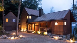 A modern log cabin with a stone foundation, a large porch, and a garage. - Four One Two Lodge at Eagles Nest, views, outdoor fireplace (Banner Elk)