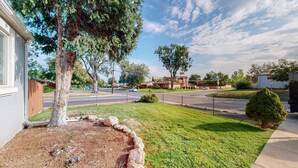 Una calle residencial con casas, una señal de stop y un césped bien cuidado.