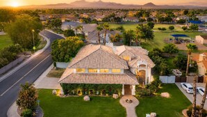 A residential house with a tiled roof, a well-maintained lawn, and a driveway. - The Gatsby I By Hotel Home Stays (Mesa)