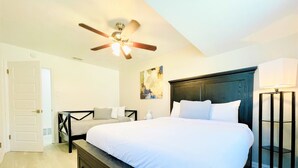 A bedroom with a large bed, a ceiling fan, a nightstand, a lamp, and a painting on the wall. - Walk to the AT&T Stadium, Texas Rangers Globe Life Park, Texas Live & many more. (Arlington)