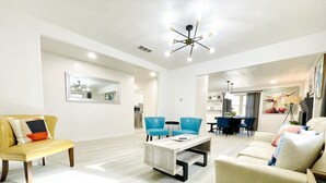 A modern living room with a sofa, armchairs, a coffee table, and a dining area. - Walk to the AT&T Stadium, Texas Rangers Globe Life Park, Texas Live & many more. (Arlington)