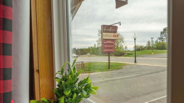 A view from a window with a sign advertising online instant booking and self-check-in. - Vacation UniquEly cottage #2 (Ely)