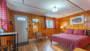 A cozy cabin room with a bed, a desk, and a chair. - Vacation UniquEly cottage #2 (Ely)