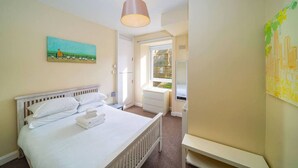 A bedroom with a bed, a painting, a window, and a radiator. - Manor Place - Convenience and Style (Broughty Ferry, Dundee)