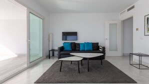 A modern living room with a sofa, coffee table, and a TV. - Nice Apartment with a Sunny Terrace, Pool & Sea View (Benalmádena)