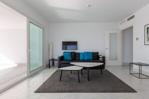 A modern living room with a sofa, coffee table, and a TV.