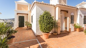 A residential building with a tiled patio, a door, and a potted plant. - Homely apartment, 2 big terraces, stunning views and pool (Nerja)
