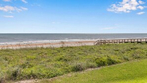 A beach with a wooden boardwalk leading to the shore.