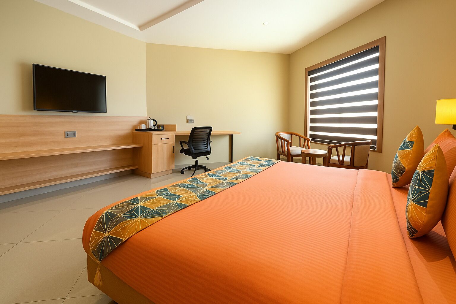 A hotel room with a bed, a desk, a chair, a television, and a window with blinds.