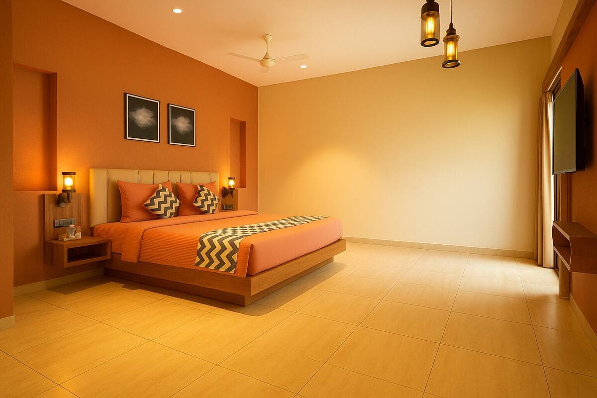 A modern bedroom with a large bed, two wall-mounted picture frames, a bedside table with a lamp, and a ceiling fan.