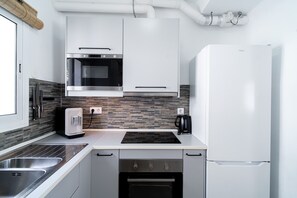 Una cocina moderna con electrodomésticos de acero inoxidable, lavavajillas y horno empotrado.