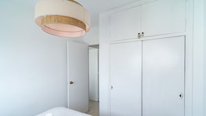 Et hotelværelse med en seng, et klædeskab og en dør til et andet rum.