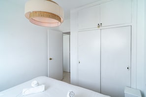 Ein Hotelzimmer mit einem Bett, einem Kleiderschrank und einer Tür zu einem anderen Raum.