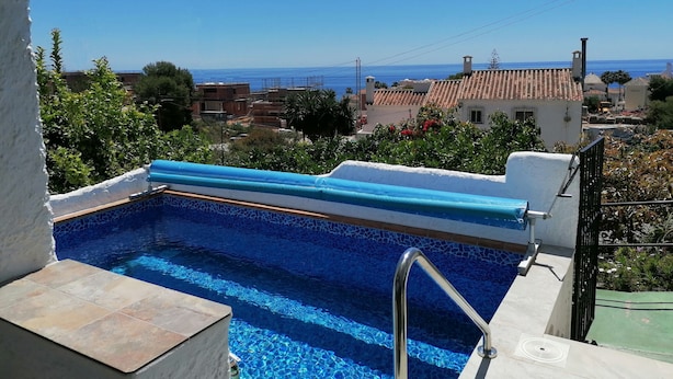 Une piscine sur le toit offrant une vue dégagée sur la mer et les bâtiments environnants.