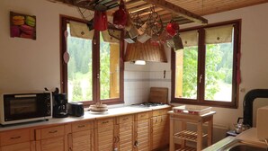 Una cocina con armarios de madera, microondas, cafetera y un lavabo.
