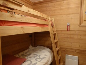 A bunk bed with a ladder, wooden walls, and a small heater on the floor. - Modern Apartment - 2BR - Sleeps 6 - Balcony - Mountain Views - Ski Shuttle - Village Center Nearby (Arêches-Beaufort)