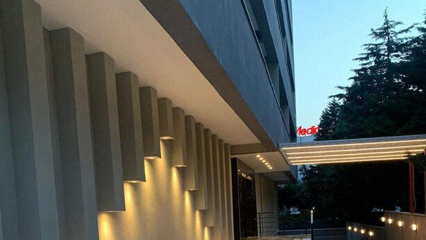 Un bâtiment moderne avec un chemin en briques menant à une entrée abritée.