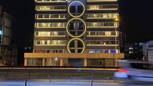 Un hôtel à plusieurs étages, sur lequel on peut lire en grandes lettres au sommet : « ROYAL RESIDENCE ».