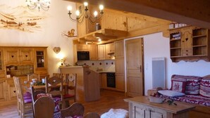 A cozy wooden interior with a dining area, kitchen, and seating space.