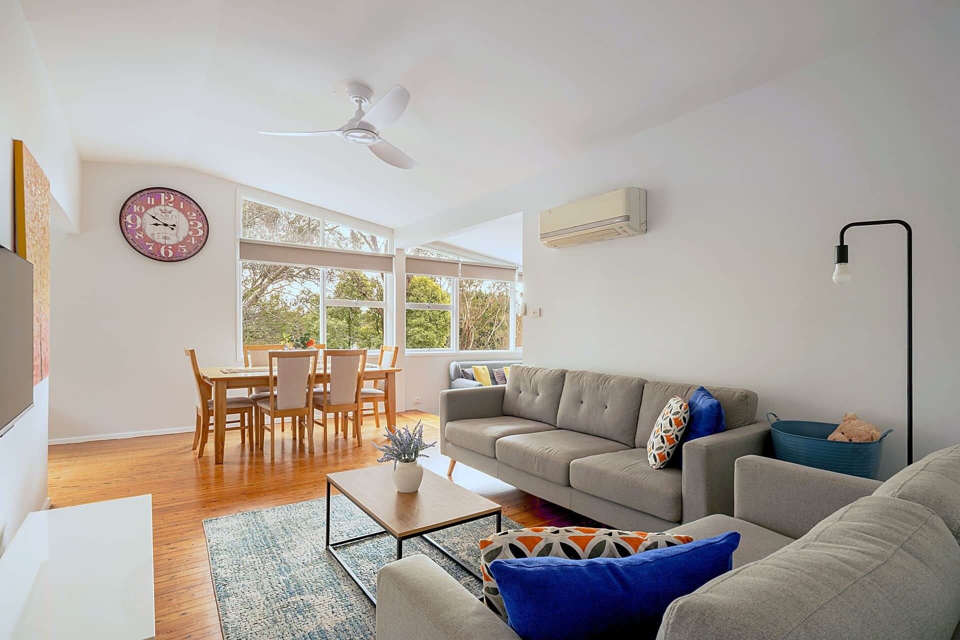 A living room with a sofa, coffee table, and a dining area with chairs.