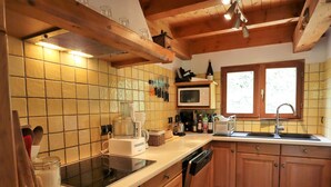 A kitchen with a microwave, toaster, sink, and wooden cabinets. - Family Chalet: Sleeps 10, Near Village & Slopes, WiFi, Fireplace, BBQ, Game Room (Arêches-Beaufort)