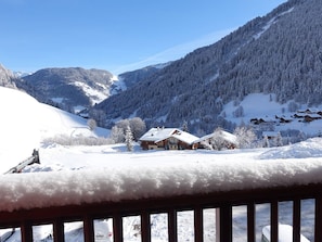 A snow-covered mountain landscape with a wooden cabin and a ski lift in the background.