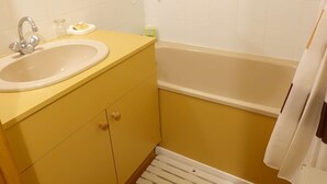 Een badkamer met een wastafel, spiegel en bad.