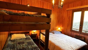A room with wooden walls, a bunk bed, a single bed, a chandelier, and a window with a view. - Chalet for 6-8 people with fireplace, south-facing and garage, 5 min from center (Arêches-Beaufort)