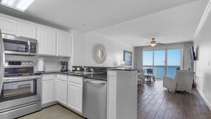 A modern kitchen with white cabinetry, a built-in oven, and a coffee maker.