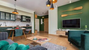 A modern living room with a sofa, a coffee table, and a TV mounted on the wall.