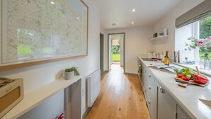 Une cuisine moderne dotée d’une grande carte, d’un plancher en bois et offrant une vue sur l’extérieur.