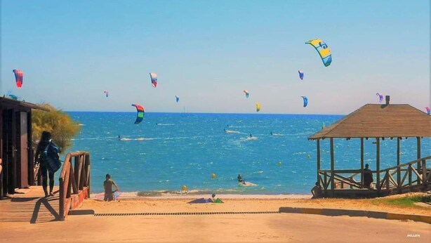 A beach with a wooden structure and a clear blue sky. - COSTA DE LA LUZ APARTMENT (Rota)