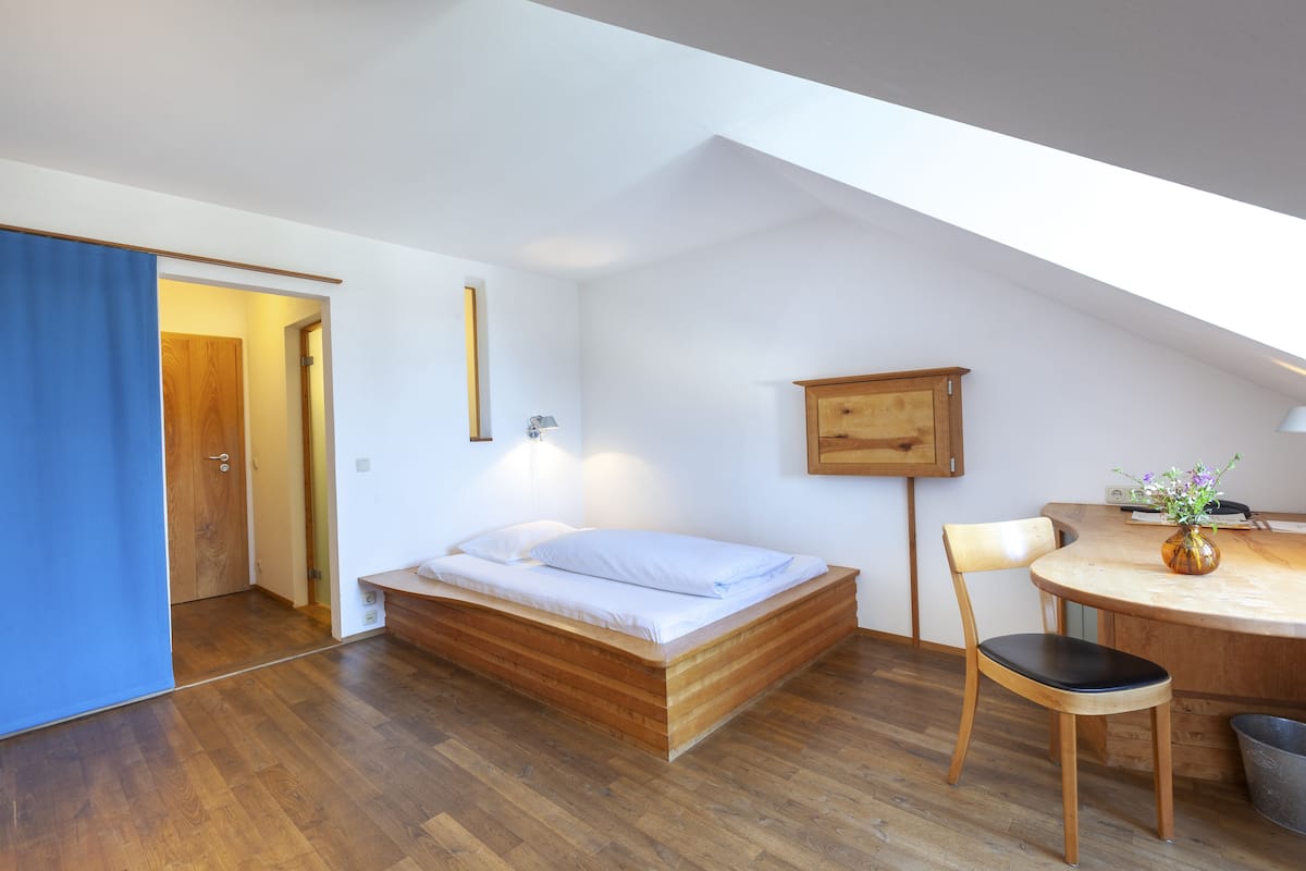 A modern bedroom with a wooden bed, a desk, and a chair.