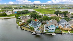 Zona residencial con casas a orillas de un muelle y un amplio campo abierto al fondo.