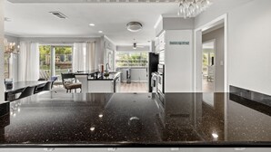 A modern kitchen with a large island, built-in appliances, and a view to the outside. - Lakeview Landing | Boat Lift • Multi-Level Deck • Walk to Moody Gardens (Galveston)