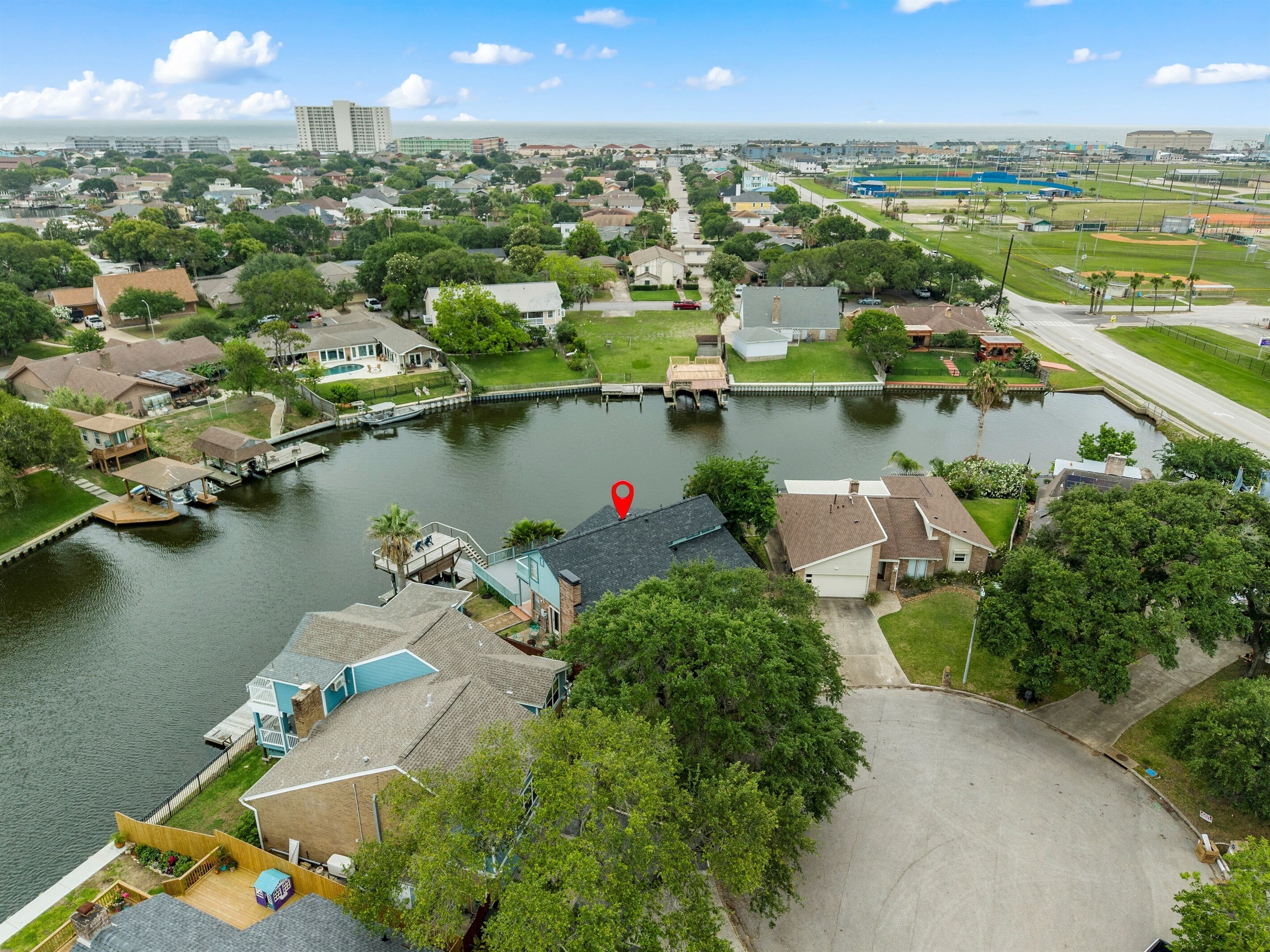 A residential area with houses, a dock, and a body of water.
