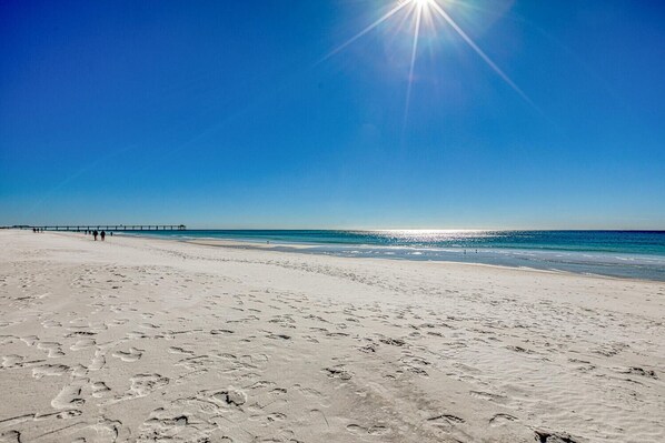 A beach with a pier extending into the water.