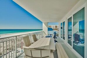 A balcony with a view of the beach and ocean.